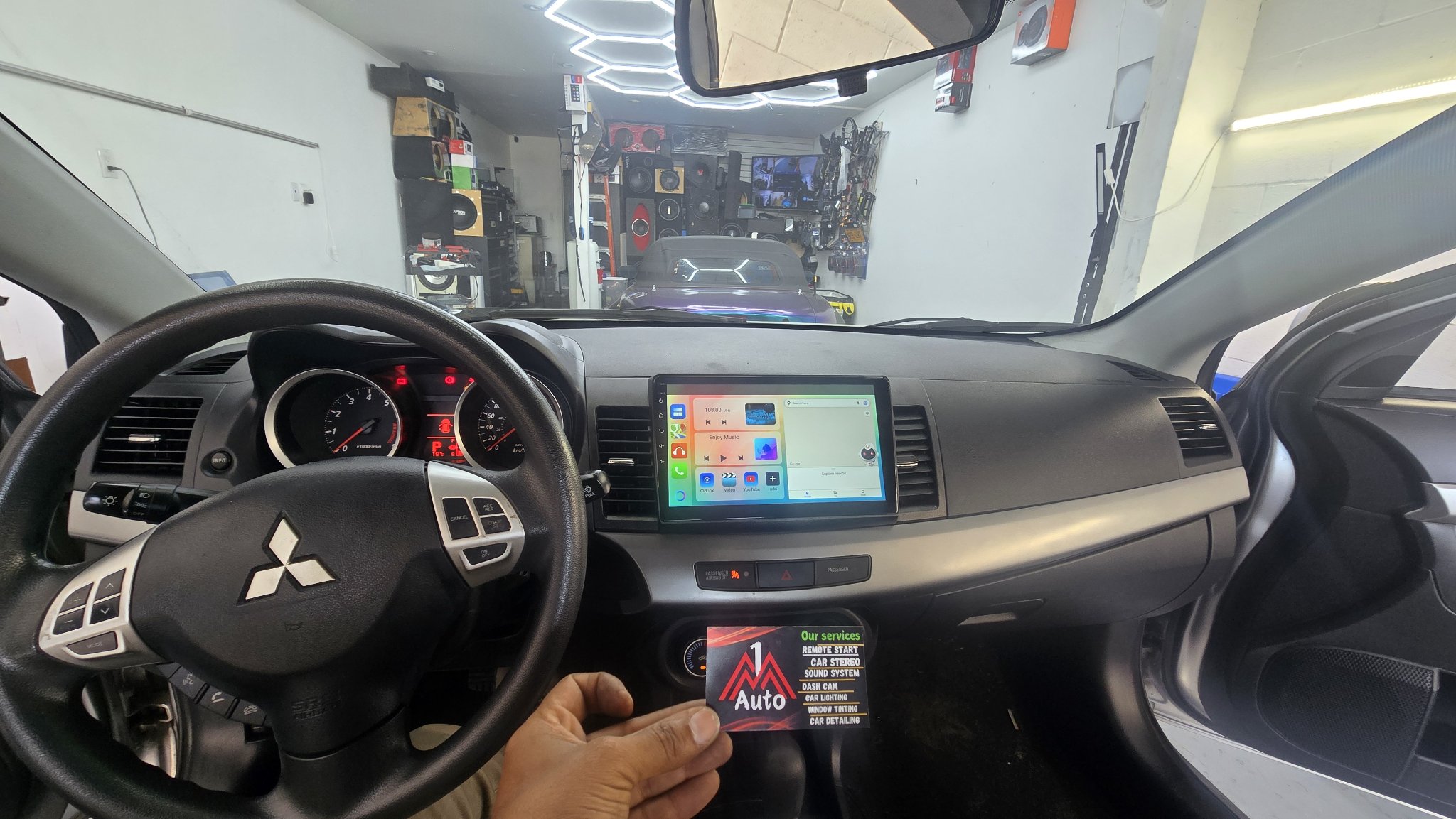 2010 Mitsubishi Lancer dashboard with a new touchscreen head unit showing CarPlay